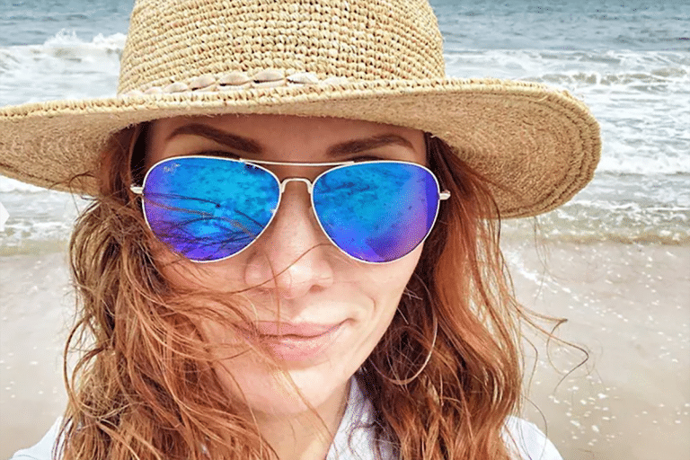 Sports sunglasses - woman on beach wearing blue tint sunglasses